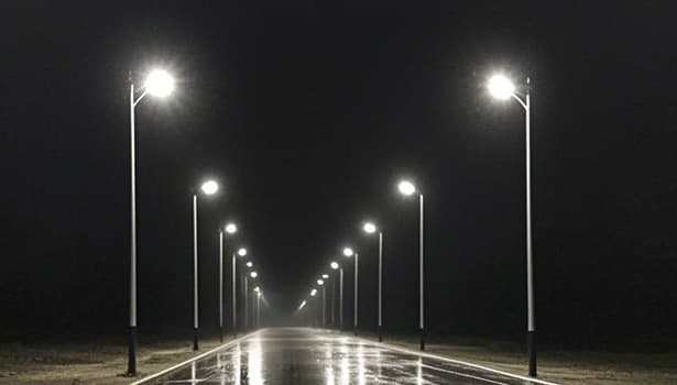 Technician inspecting solar street light components (sealing strips at lamp joints, circuit connections) to identify rain-induced issues like moisture infiltration or corrosion.