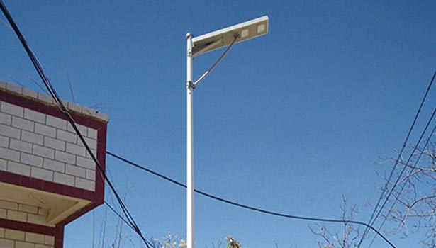 Close-up of solar street light in countryside showing panel and LED lamp
