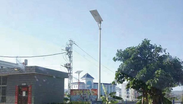 Village solar street lights installed on rural road with wide pole spacing