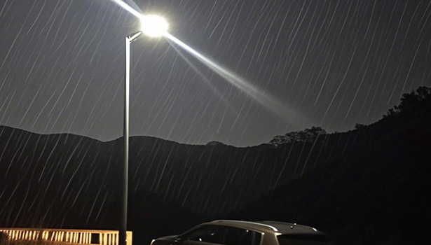 Solar street light illuminating in heavy rain at night