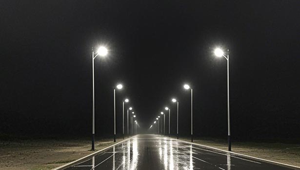 Solar street lights lighting an empty wet road at night