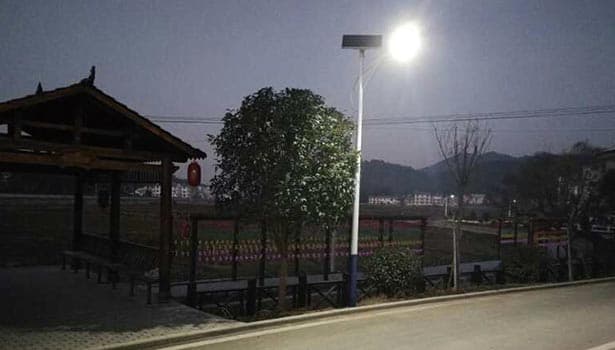 A solar street light near a pavilion at night.