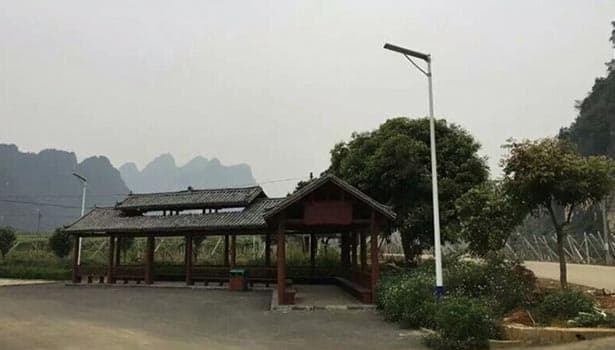 Solar street light near a traditional-style pavilion, showing its use in scenic or recreational areas