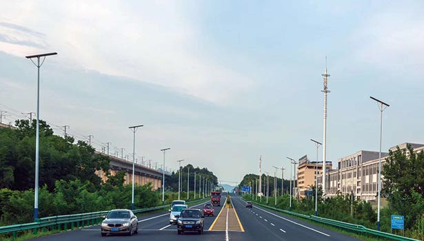 Solar street lights along a highway passing through an urban area, demonstrating highway solar lighting system application