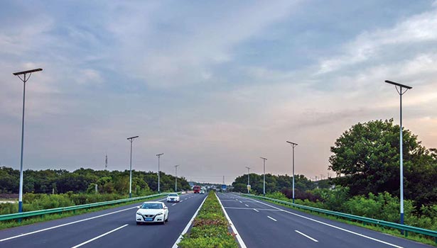 Multiple solar street lights illuminating a multi - lane highway with vehicles, highlighting smart highway solar lighting