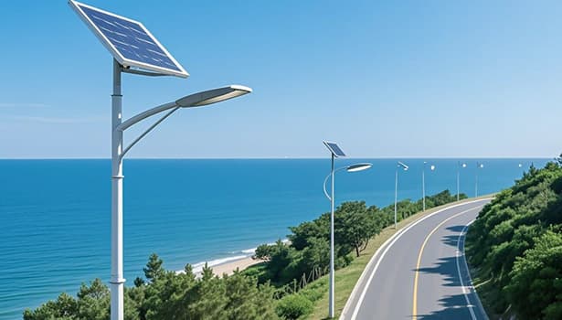 Solar street lights installed along a coastal road with the sea and clear blue sky in view