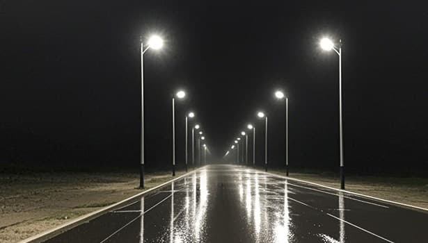 Solar street lights brightly lighting up a wet road at night