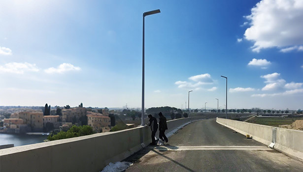 Solar street lights installed along an urban bridge, with two people nearby, illustrating urban application