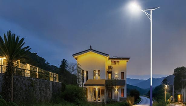 A solar street light brightens a residential neighborhood at night, providing energy-efficient home perimeter illumination.