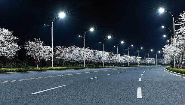 Solar street lights light up an urban community road with cherry blossoms at night, blending functionality and aesthetic appeal.