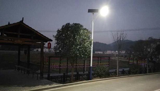 Solar street lights installed along a suburban road, illustrating cost-effective and eco-friendly lighting solutions for rural or urban outskirts.