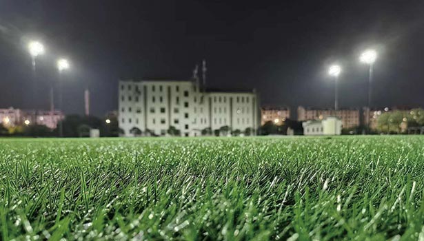 Solar street lights lighting up a sports field at night, highlighting powerful and sustainable outdoor illumination for recreational areas.