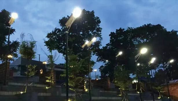 Park solar street lights lighting up a garden area at dusk, demonstrating energy-efficient outdoor lighting for public spaces.