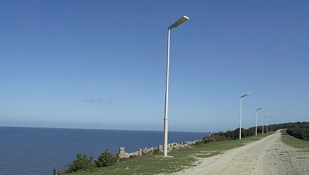 Solar street lights installed along a rural coastal road, demonstrating long-term durability in open environments.