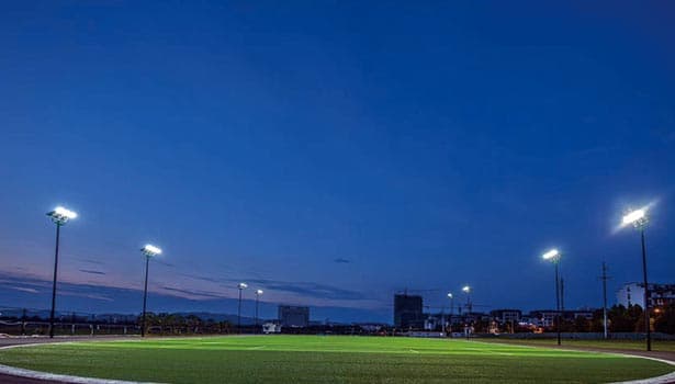 Solar-powered stadium lights illuminating a sports field at night