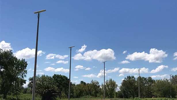 Solar street lights installed in an outdoor park under a clear blue sky