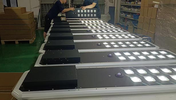 Workers assembling solar street lights in a factory production line