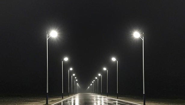 Solar street lights automatically turned on illuminating a rainy night road