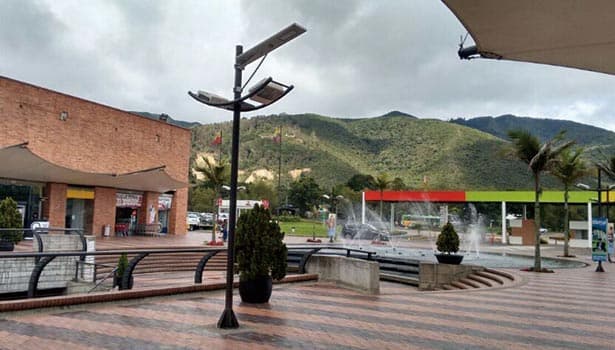 Solar street lights installed in a commercial plaza with fountains and buildings, showcasing versatile solar lighting for public spaces.